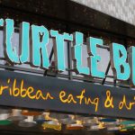 Exterior signage in turquoise letters for Turtle Bay Caribbean style restaurant, Walthamstow branch East London.